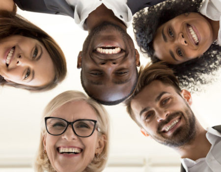 Low angle shot of excited work employees standing in circle