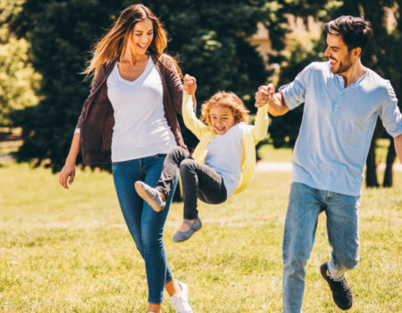 Parents swinging their daughter in the air